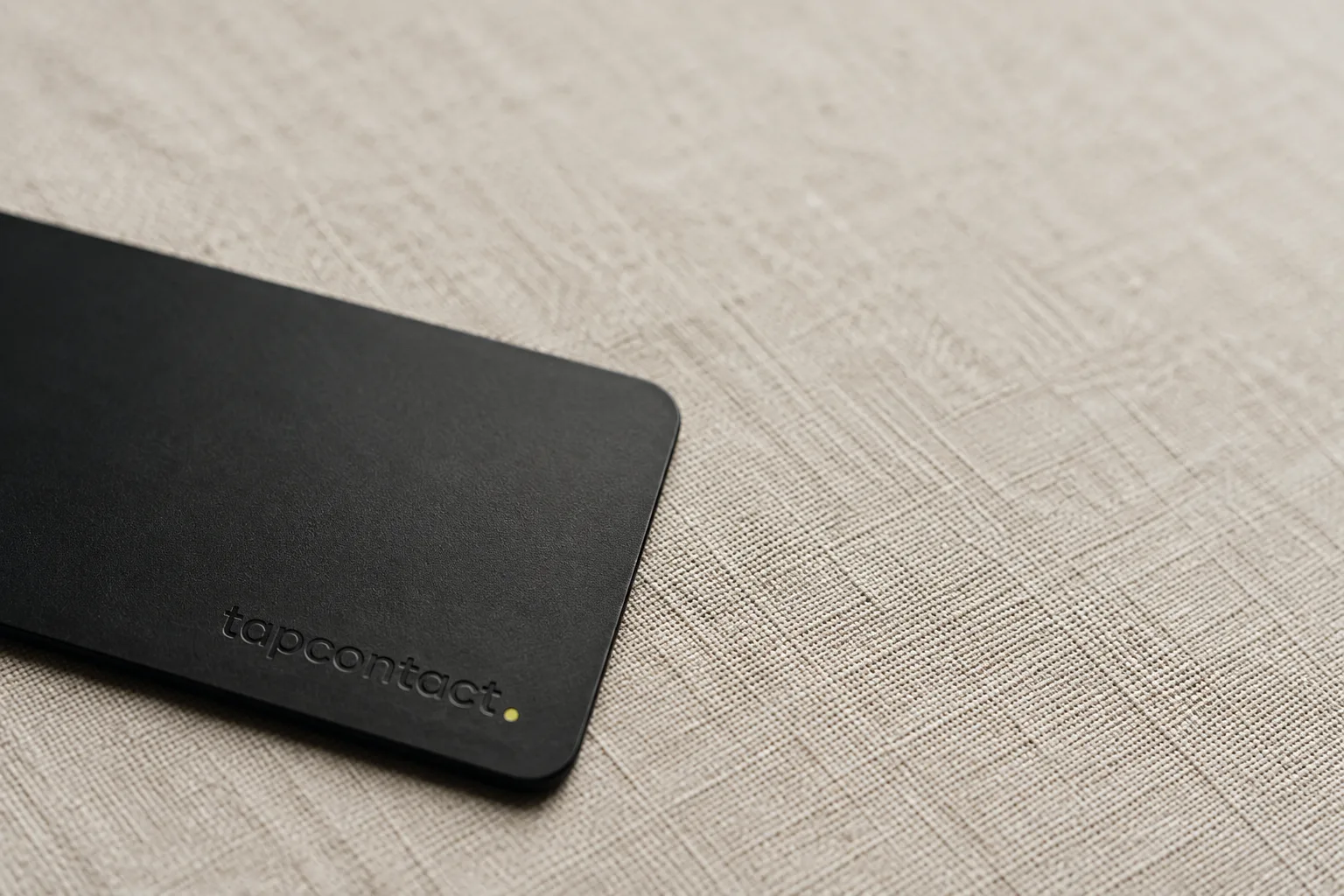 Matte black tapcontact NFC card on linen