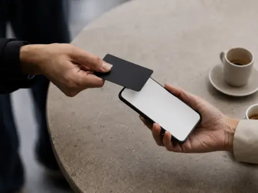 Card tapped against a phone at a coffee table