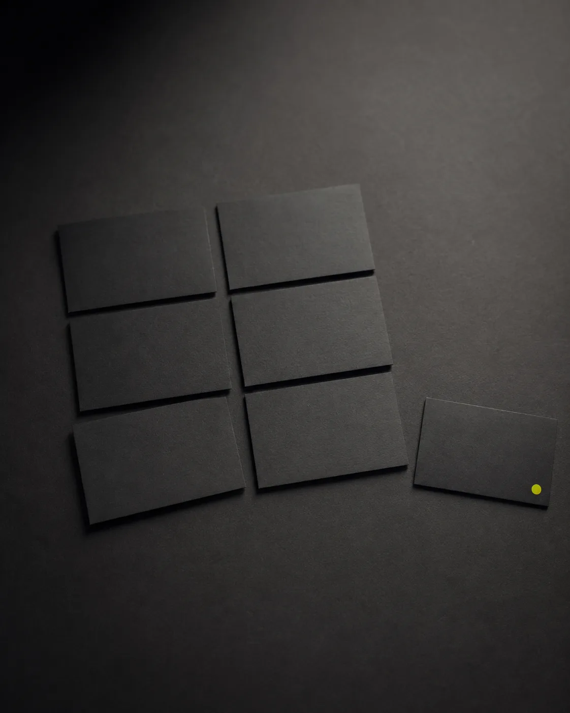 Grid of black cards on a dark desk, one out of line